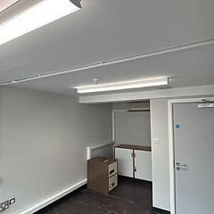 Redecorated commercial corridor with light grey walls and fire door