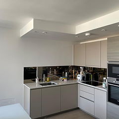 Kitchen with taupe handleless cabinets and mirrored splashback
