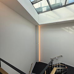 Office stairwell with white walls, glass skylight and LED light recess