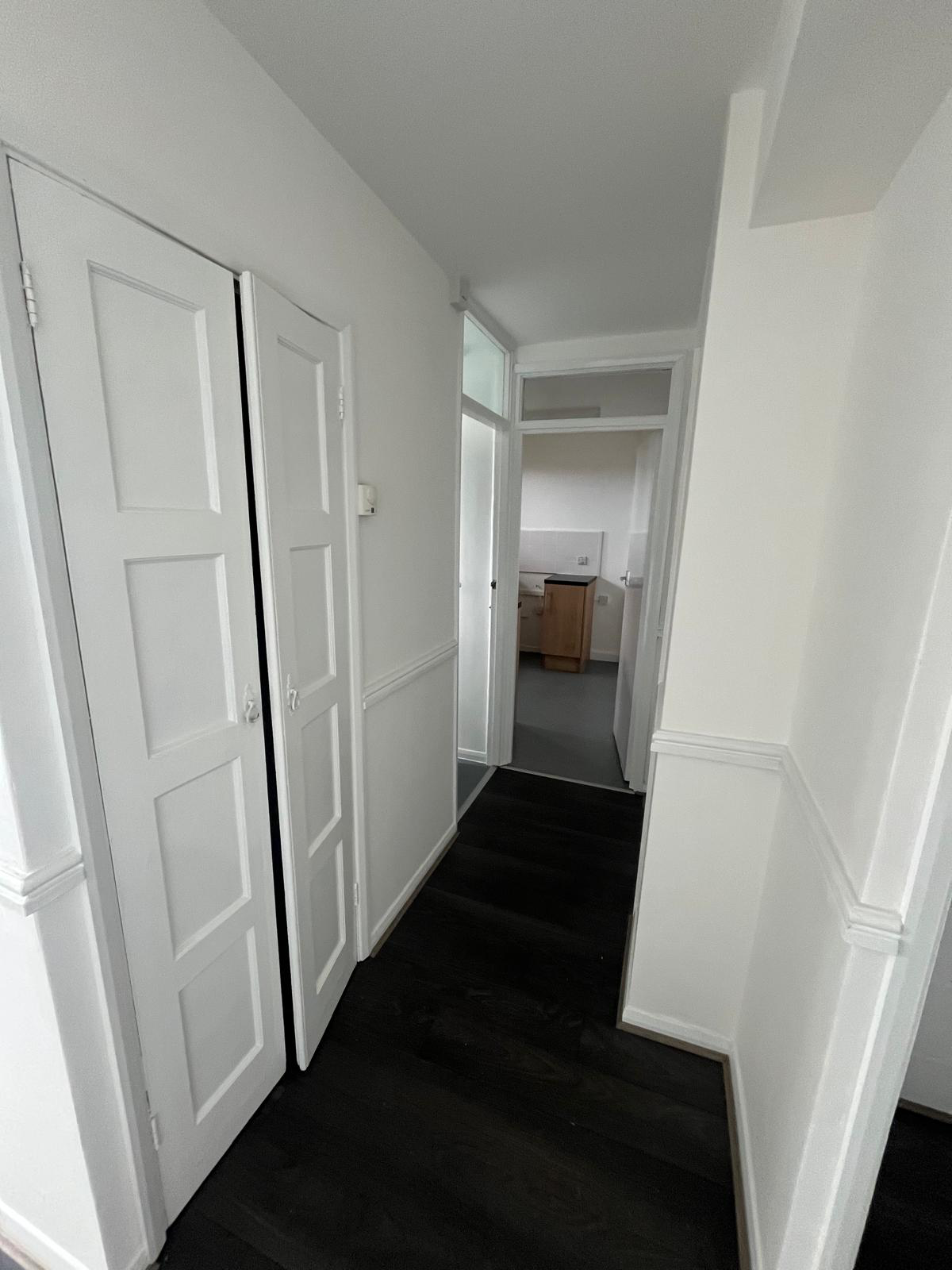 Freshly decorated hallway with white panelled doors leading to the kitchen