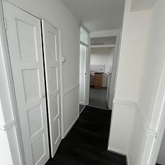 Freshly decorated hallway with white panelled doors leading to the kitchen