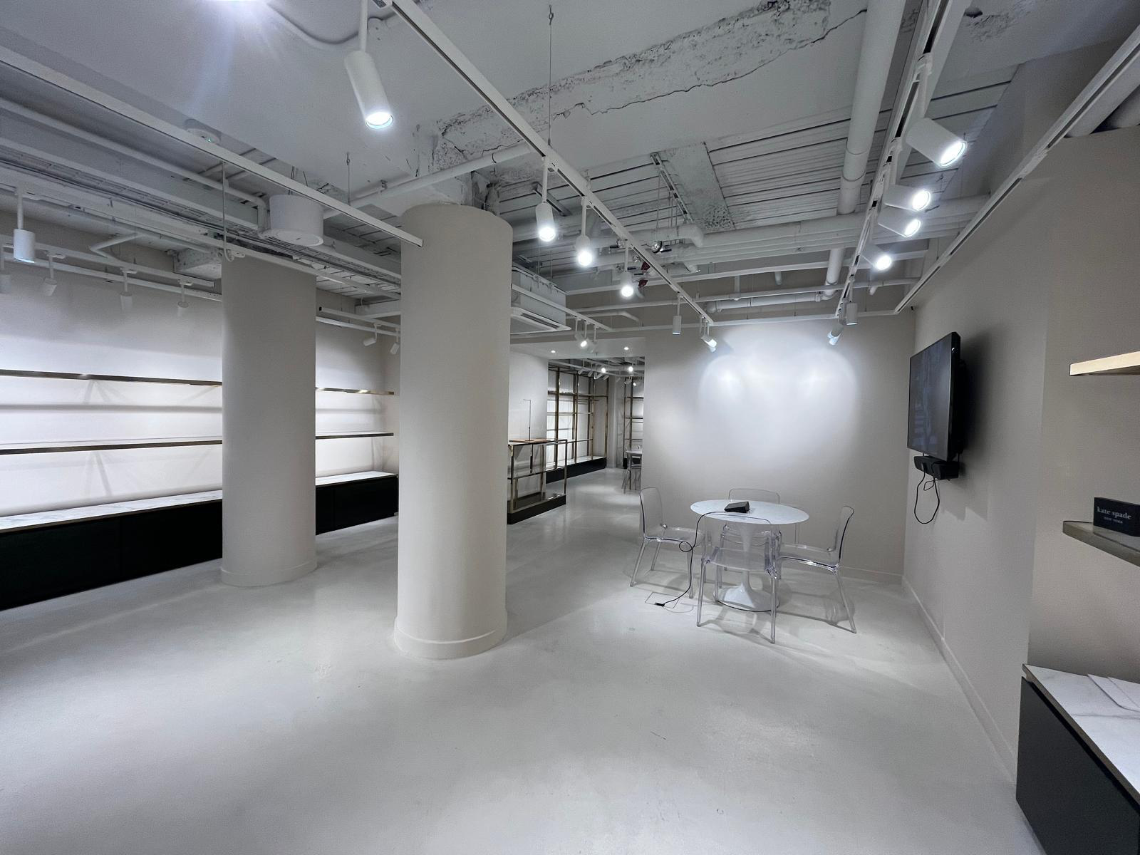 Retail showroom with soft greige walls, painted columns and polished floor