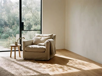 A quiet chair by a window with soft light