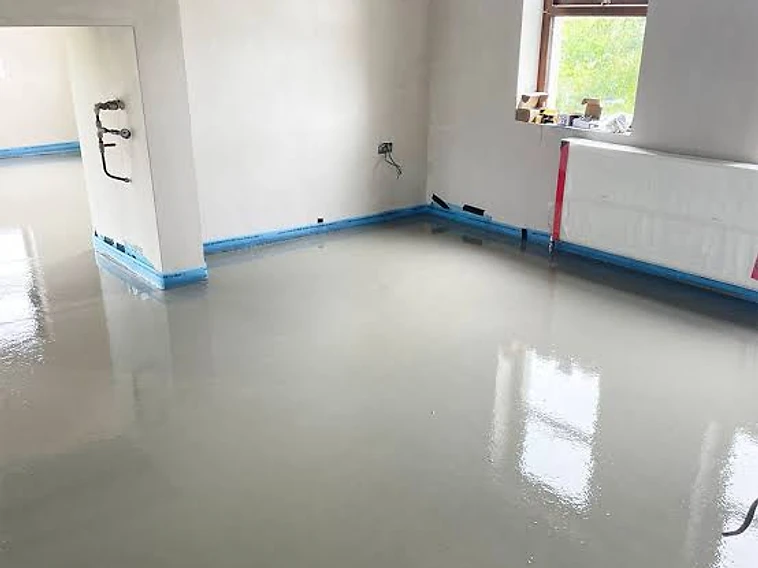 Freshly laid liquid screed floor with a smooth, reflective finish — MPC Plastering