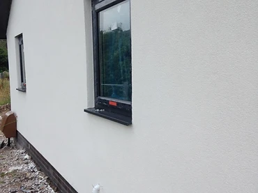 EWI finished wall with off-white render and dark plinth, Mayo