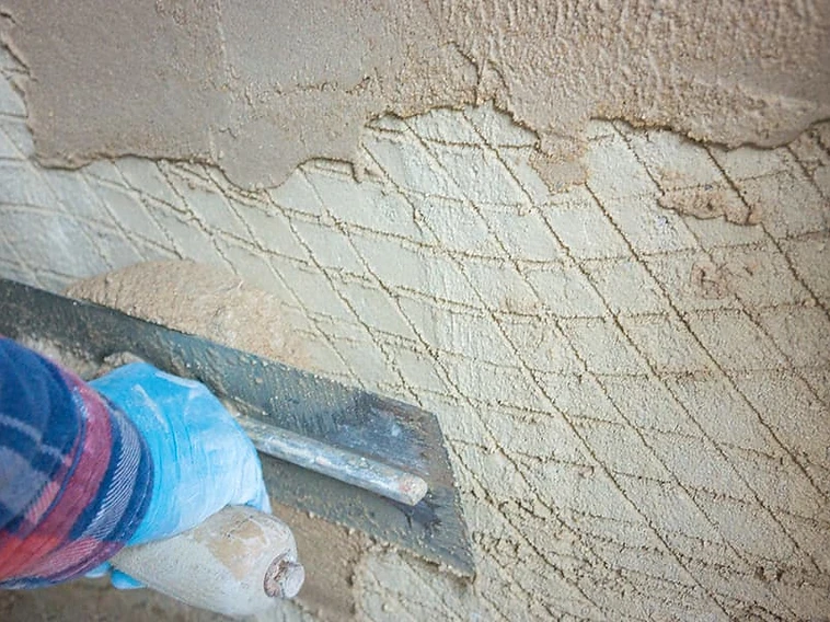 Applying lime mortar over a scratched key coat — traditional craft technique