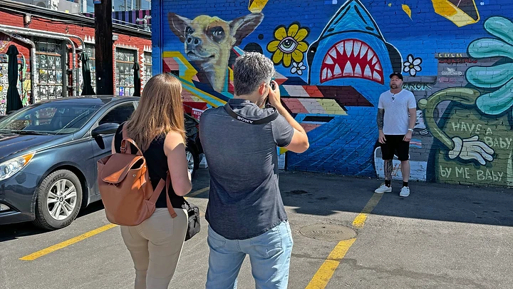 Ben and Shira working together on a BluPoetry production in front of a colorful mural.