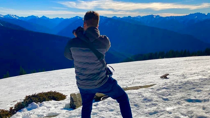Ben photographing snow-covered mountains during Ben and Shira's journey across the United States.