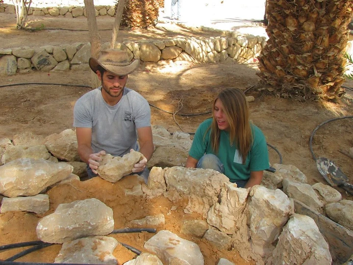 Ben and Shira building stone landscaping at Kibbutz Ketura.