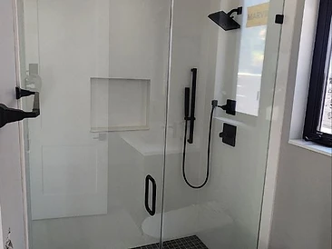 Modern walk-in shower with matte black fixtures and frameless glass enclosure