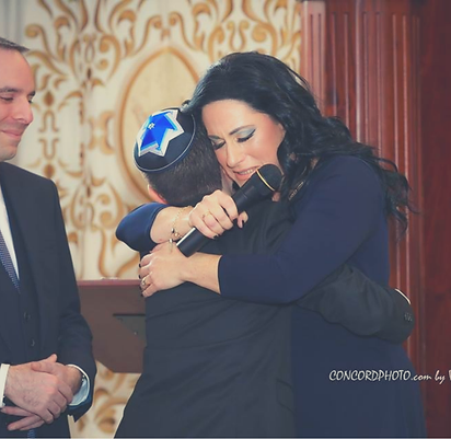 A mother embracing her son at his Bar Mitzvah celebration