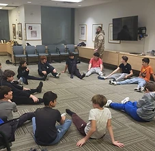 BMC boys stretching in a circle during a Krav Maga self-defense class