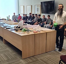 Rabbi Benny leading a hands-on activity with the boys