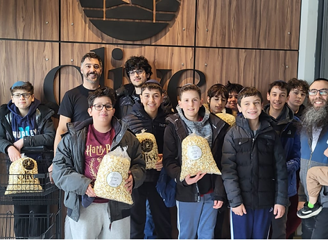 BMC boys holding bags of popcorn on a club outing