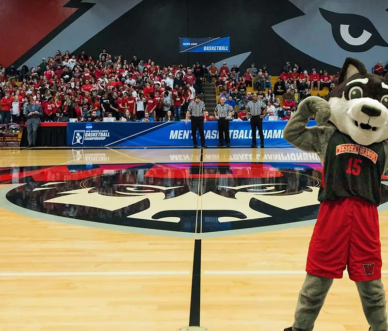 Wolfie the Wolf on the court in front of a packed Western Oregon crowd
