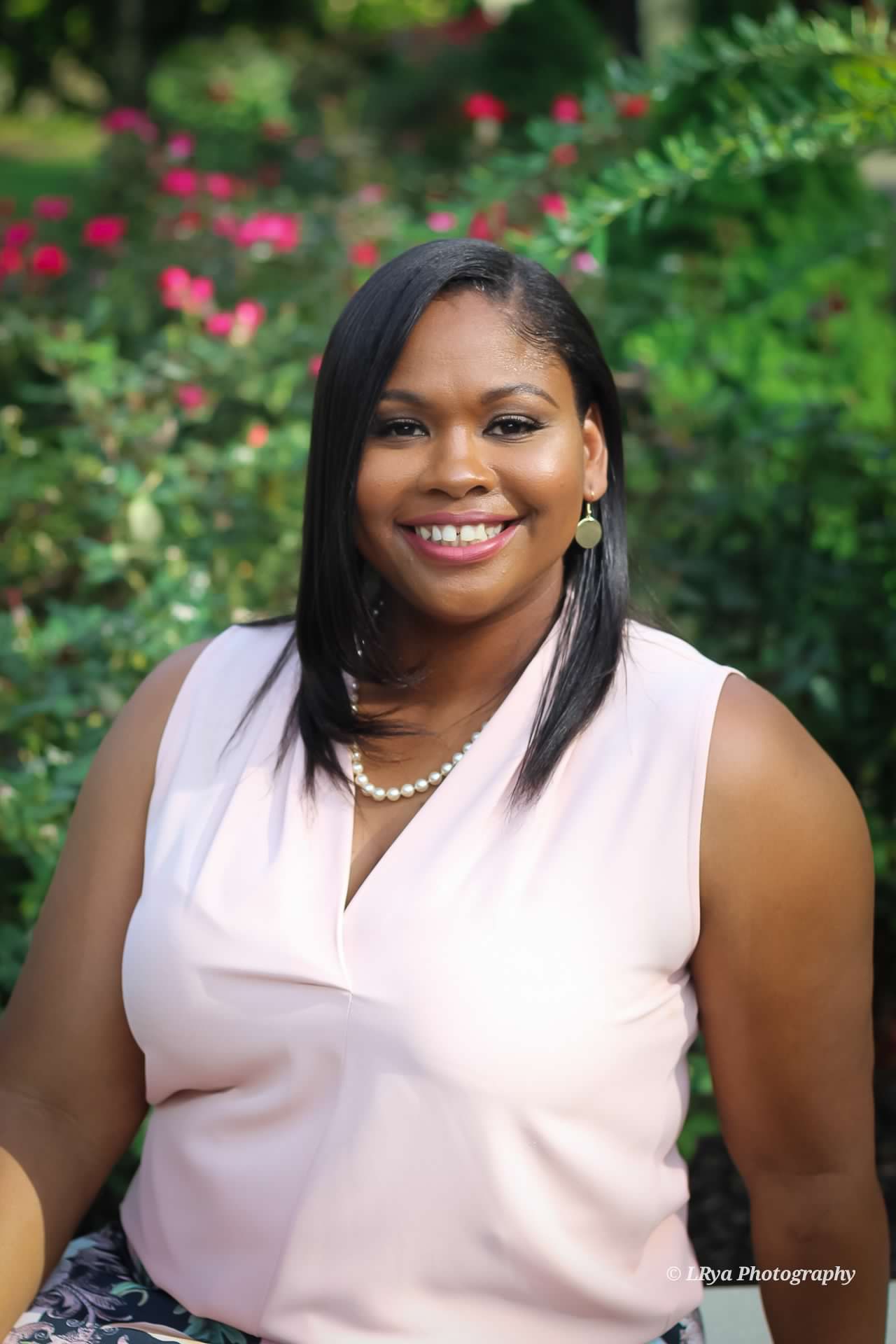 Portrait of therapist Marirhetta Crosby, smiling warmly in a garden setting