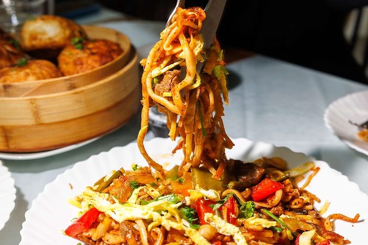 Lifting hand-pulled noodles with tongs