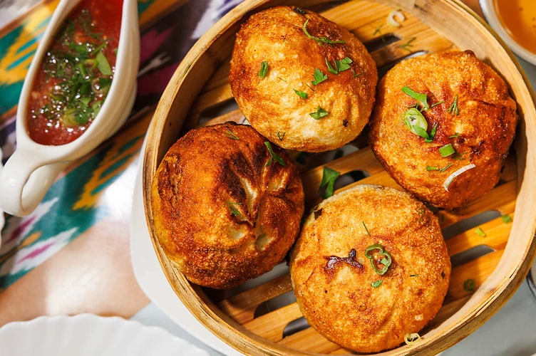 Golden fried samsa in a bamboo steamer