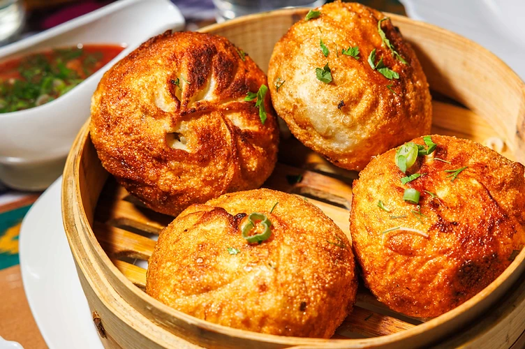 Fried samsa pastry torn open to reveal the filling