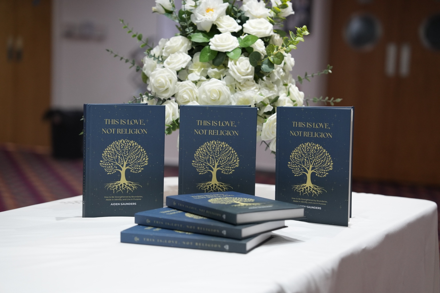 Copies of This Is Love, Not Religion displayed at an event
