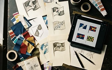 A designer's desk with football flag artwork sketches and colour swatches