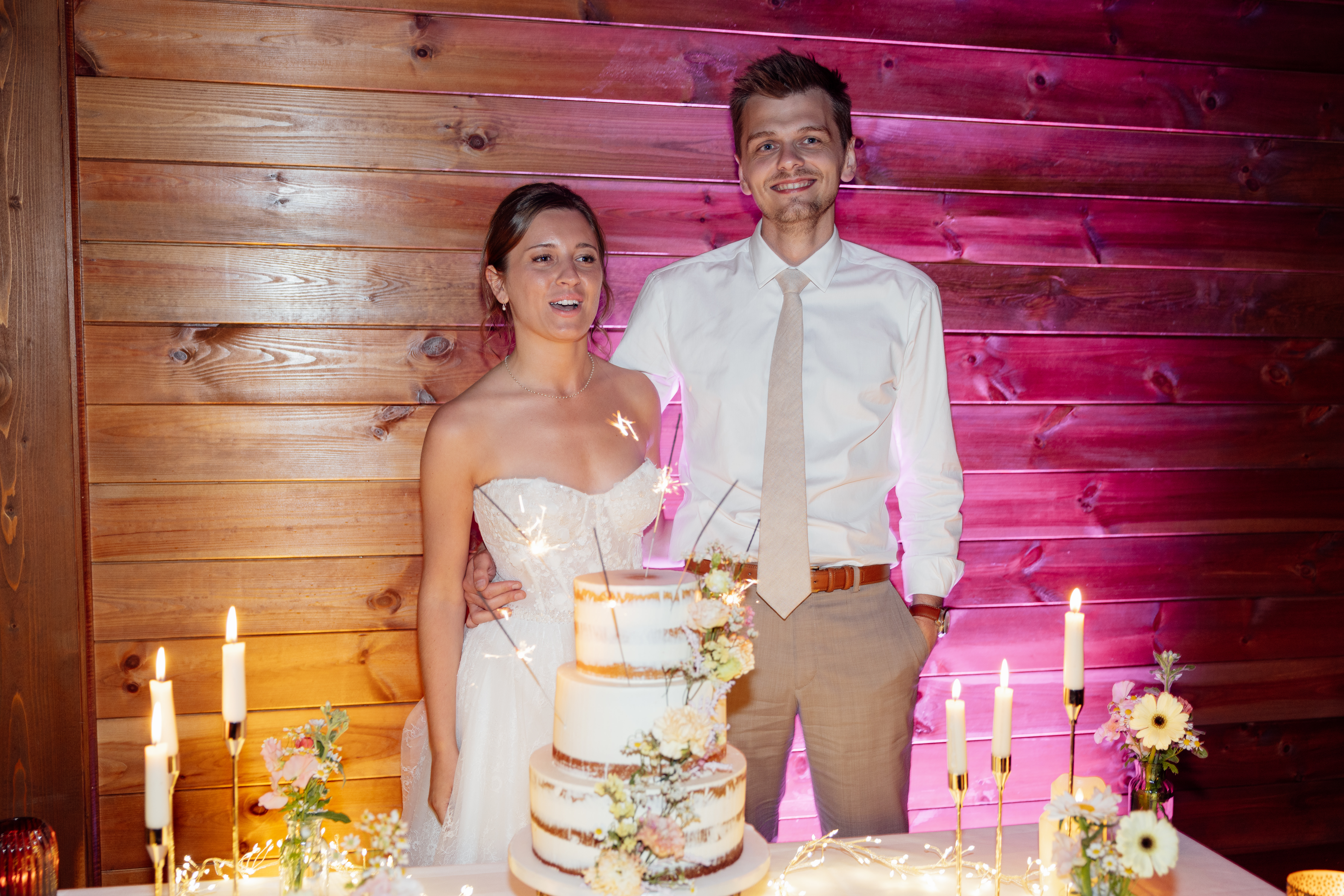 Clémence & Corentin derrière leur pièce montée — mariage aux Orangers du Château