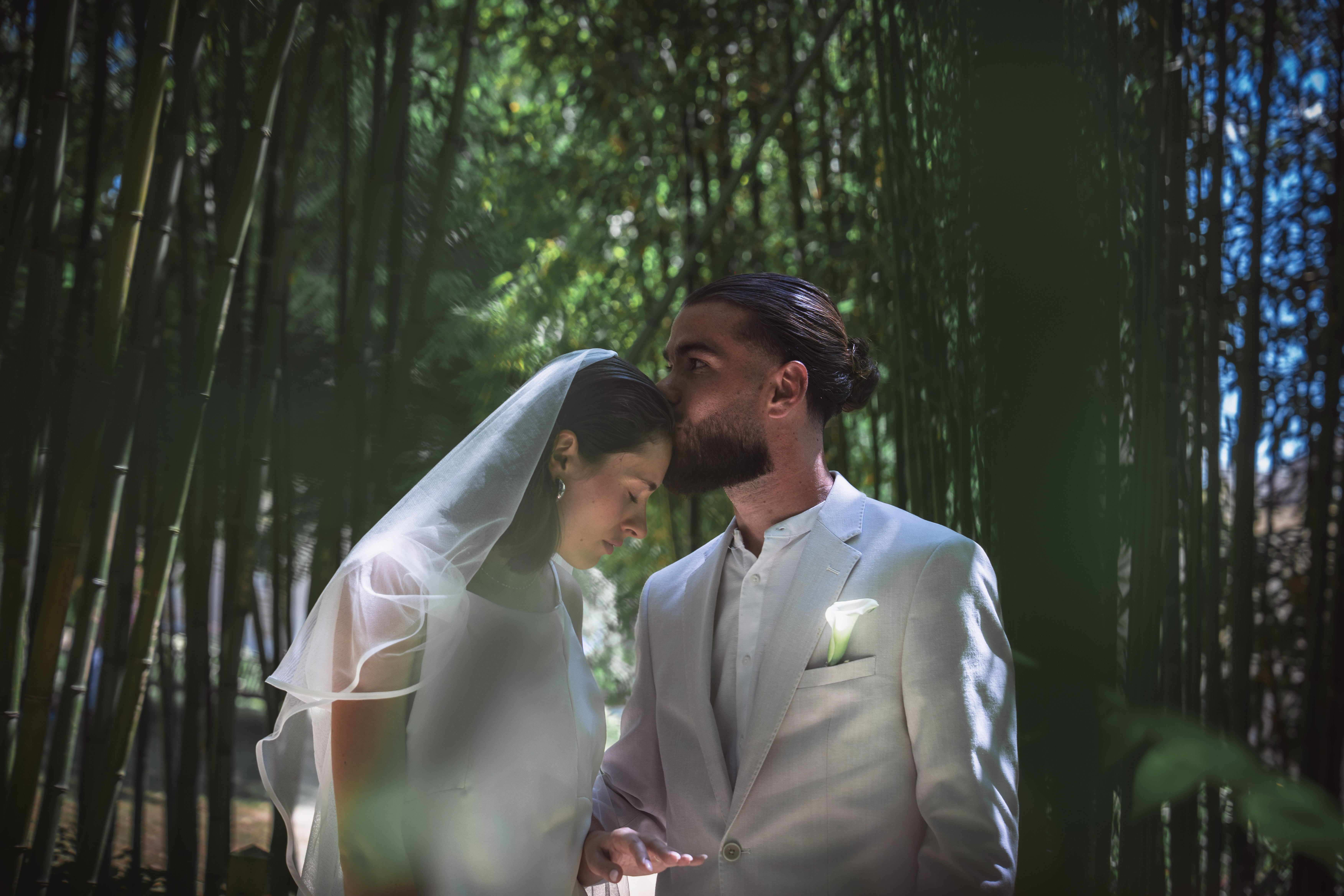 Mariage Lola & Alexis — baiser tendre dans une clairière de bambous