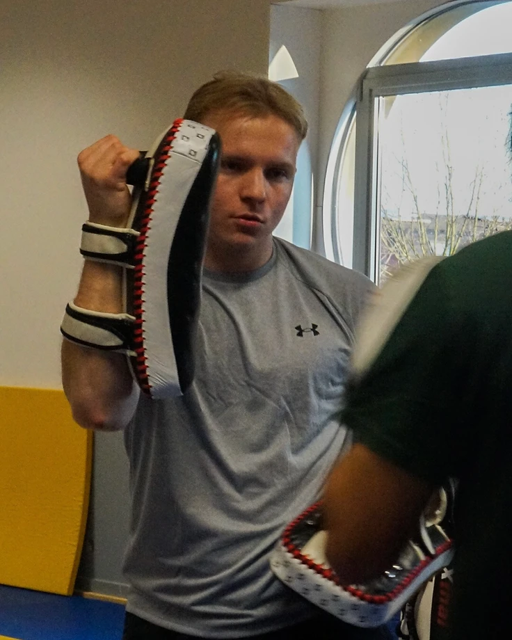 Portret van de Battleshape trainer met kickboxpads