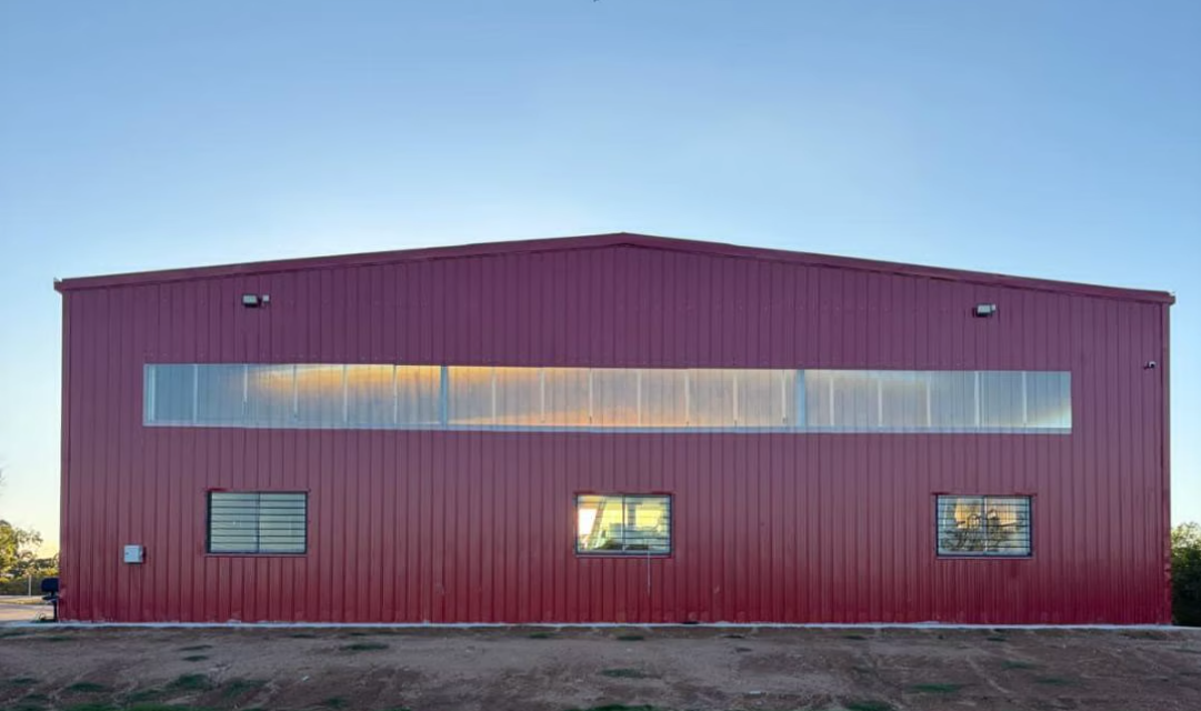 Completed red pre-engineered steel building at sunset