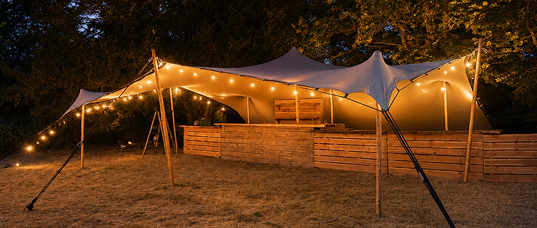 Stretch tent lit with festoon lights at dusk