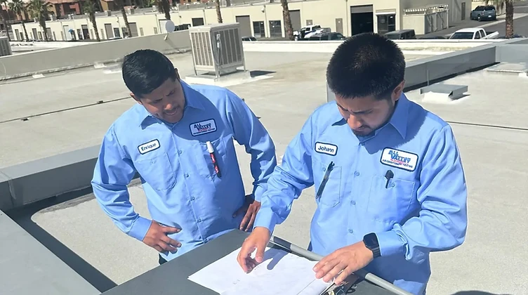 All Valley Air HVAC technicians working on a rooftop AC unit in the Coachella Valley