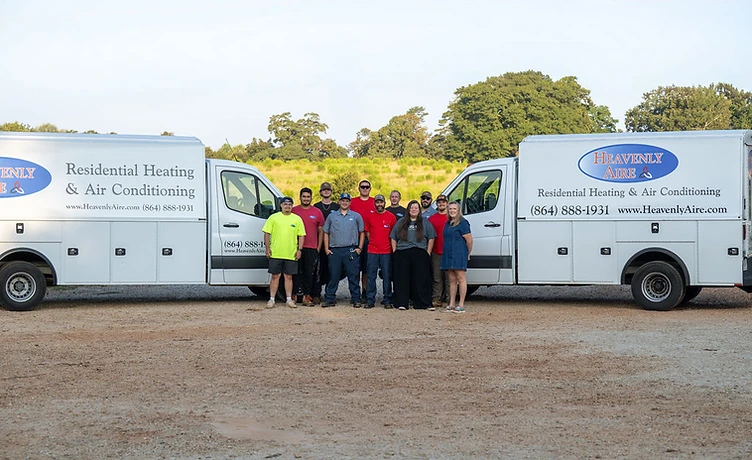 Group photo of the entire Heavenly Aire team standing in front of two company service vans at our local facility in Seneca, SC.