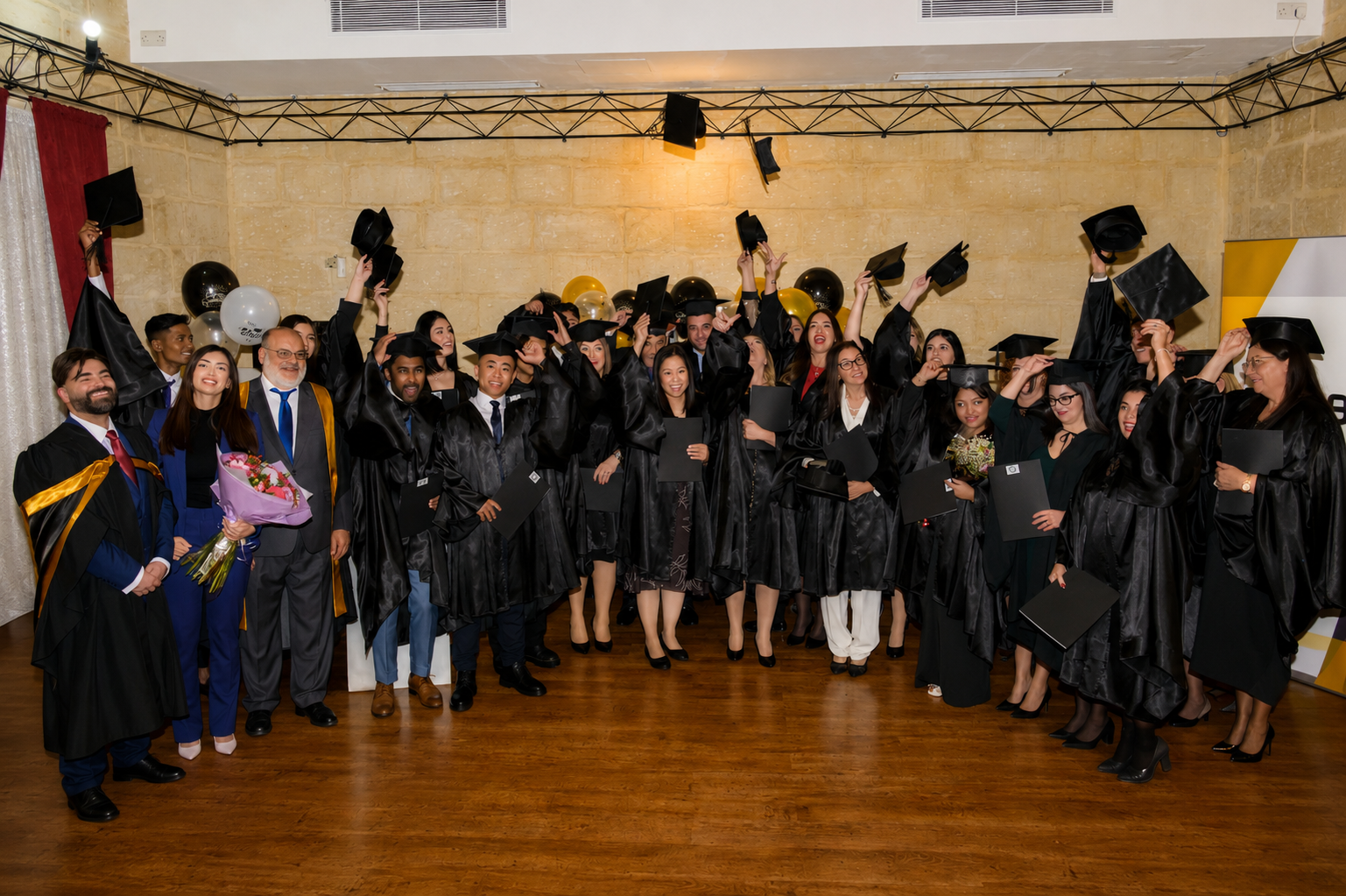 TTS graduates celebrating with mortarboards in the air