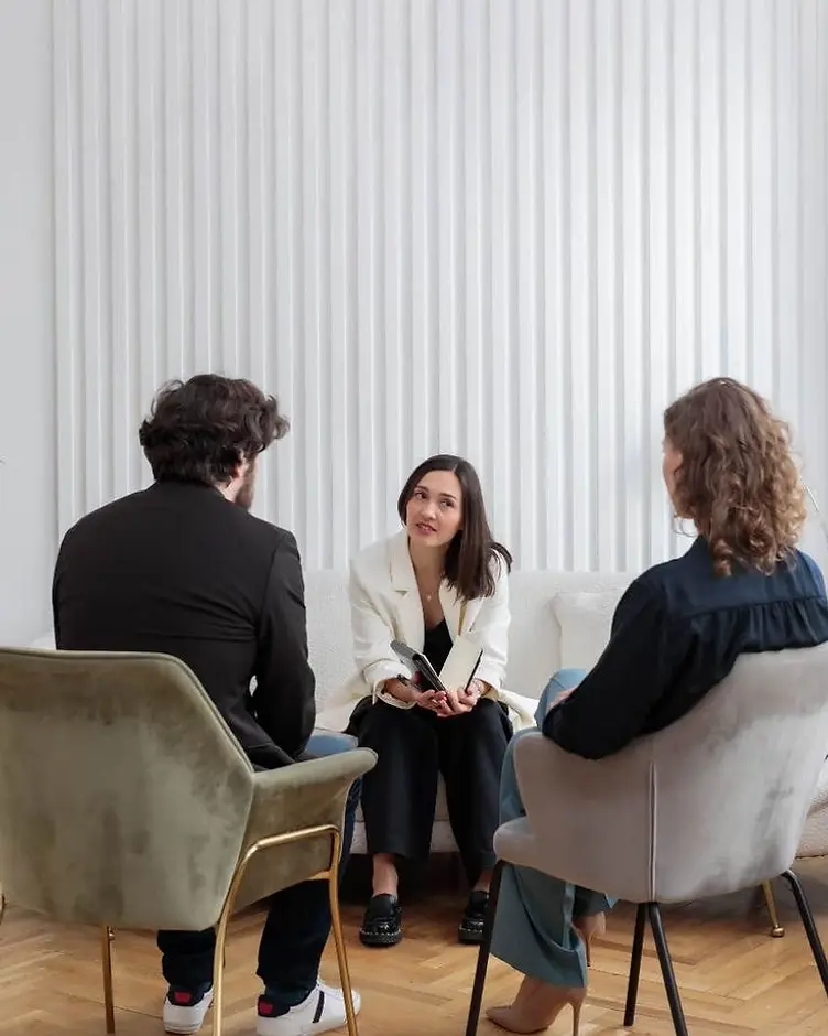 Dr. Hickey listening to a couple during a counseling session in a bright, modern office