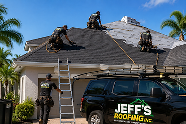 Jeff's Roofing crew installing shingles on a residential roof with company truck