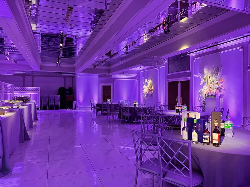 Darkened ballroom washed in warm amber uplighting