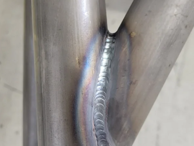 Raw TIG-welded cage joint with heat discoloration