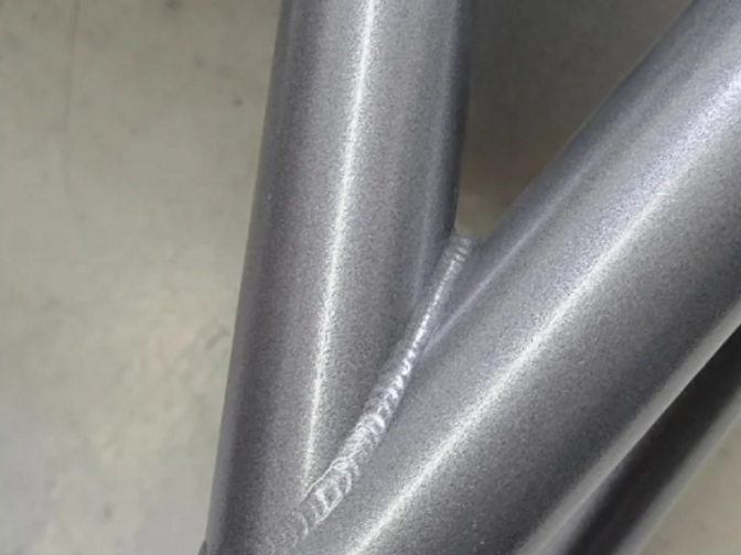 Powder-coated TIG-welded cage joint