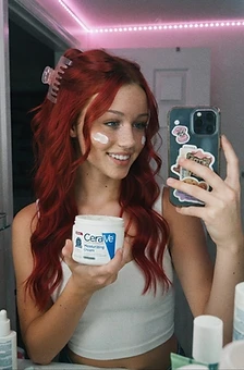 Skylar doing skincare in a mirror