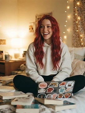 Skylar in her dorm room surrounded by books