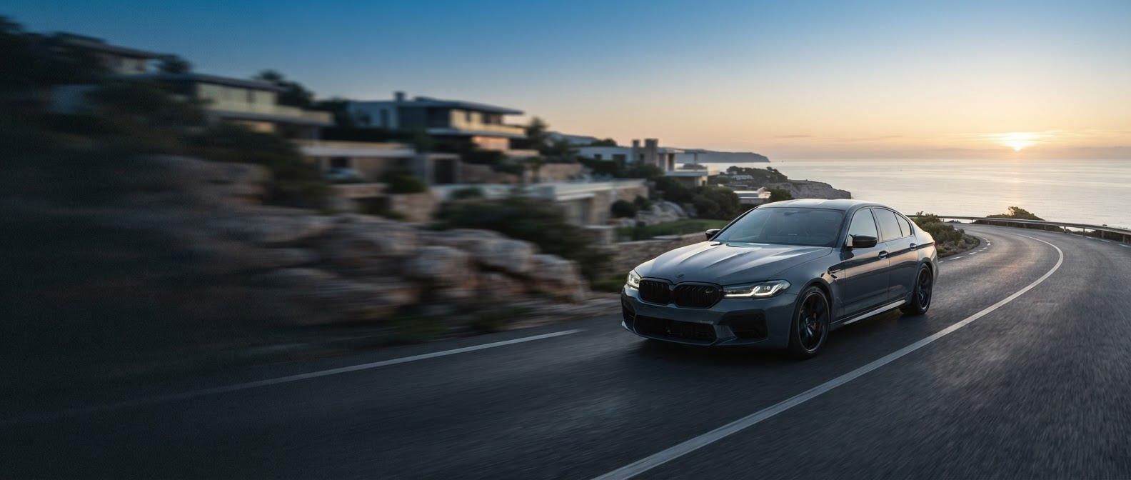 Coche moderno circulando por una carretera costera al amanecer