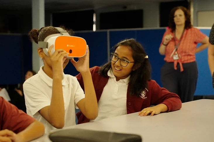 Children exploring VR headsets in a school lesson