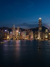 Skyline di una grande metropoli illuminata di notte, riflessa sull'acqua