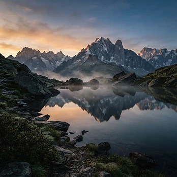 Lago alpino che riflette le montagne nella prima luce