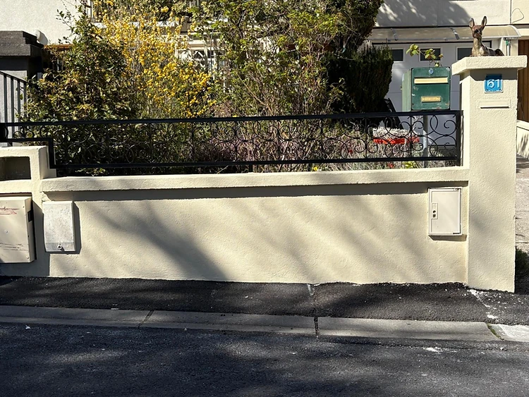 Muret de clôture après reprise d'enduit et peinture beige Muret de clôture après reprise d'enduit et peinture beige