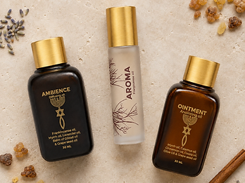 The three sacred oil bottles - Ambience, Aroma and Ointment - surrounded by the raw botanical ingredients of the Holy Land