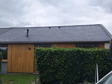 Maison à bardage bois avec toiture en ardoise rénovée