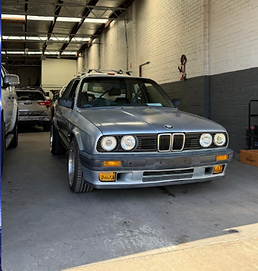 Silver BMW E30 classic sedan inside the workshop