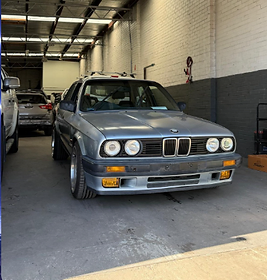 Silver BMW E30 classic sedan inside the workshop