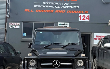 Karims Auto Repairs storefront with a Mercedes G-Class parked out front